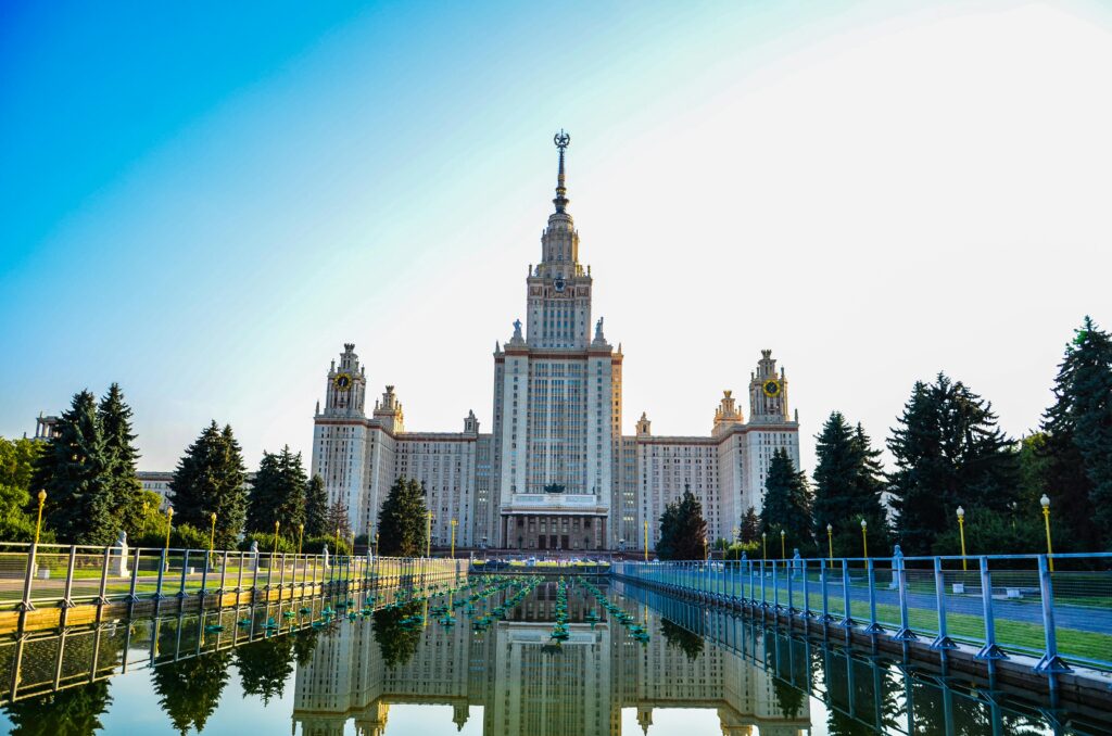 Scenic view of Moscow State University reflecting in water at sunset.