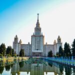 Scenic view of Moscow State University reflecting in water at sunset.