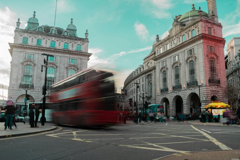 Long exposure of a red double-decker bus at Piccadilly Circus, London. Iconic urban scene.