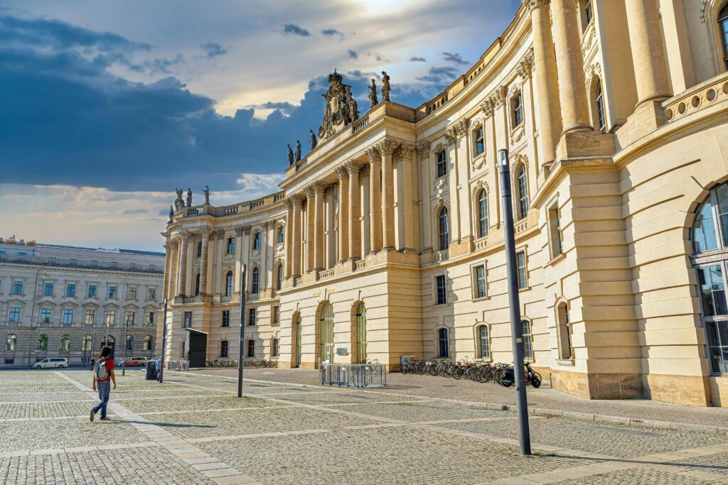 Baroque architecture at Bebelplatz in Berlin cityscape with a pedestrian and historic landmarks.